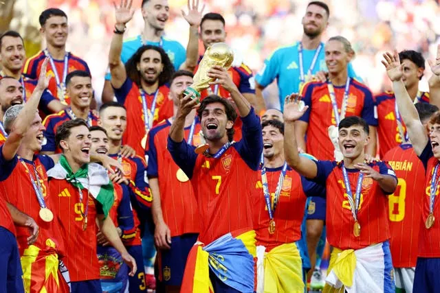 Spain's Ferran Torres lifts the trophy with teammates