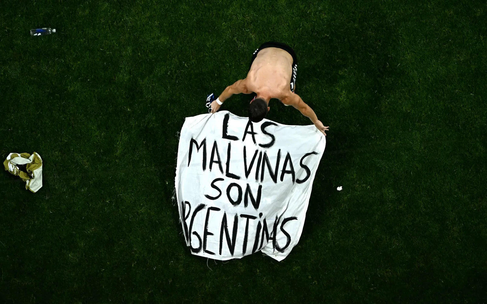 Argentina's midfielder #11 Giovani Lo Celso adjusts a banner reading "The Malvinas (Falkland Islands) belong to Argentina," after winning the 2026 World Cup football tournament semi-final match between England and Argentina at the Atlanta Stadium in Atlanta on July 15, 2026. (Photo by Jewel SAMAD / AFP)