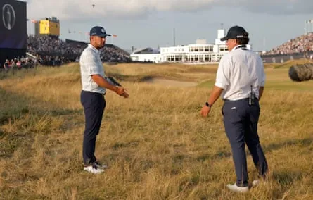 Bryson DeChambeau talks to an R&A rules official on the 18th hole of his third round
